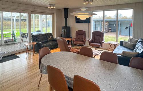 a living room with a table and chairs at Cozy Home In Fårevejle in Fårevejle