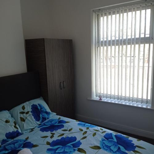 a bedroom with a bed with blue flowers on it at Double-Bedroom in the Heart of Salford Manchester Perfect for Short Stays LT1 in Manchester