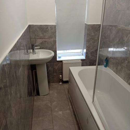 a bathroom with a sink and a toilet and a tub and a sink at Double-Bedroom in the Heart of Salford Manchester Perfect for Short Stays LT1 in Manchester