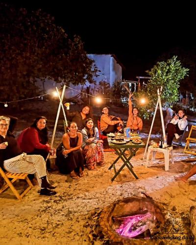 a group of people sitting around a table at night at Ecocampingdage in Buíque