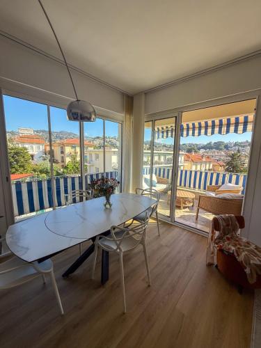 une salle à manger avec une table en verre et un balcon dans l'établissement Magnifique appartement avec grande terrasse Nice, à Nice