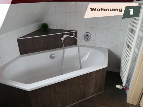 a bath tub with a faucet in a bathroom at Ferienwohnung Zum Böhmischen Bürgergarten in Radebeul
