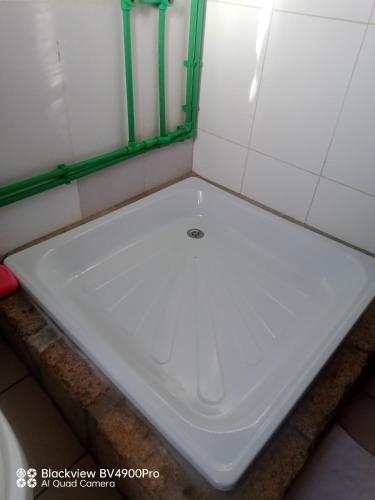 a white toilet in a bathroom with green trim at My Little House in Mandriankeniheny