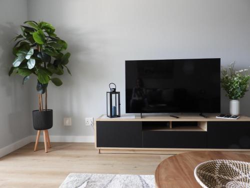 een woonkamer met een flatscreen-tv op een kast bij Central Self Catering in Swakopmund