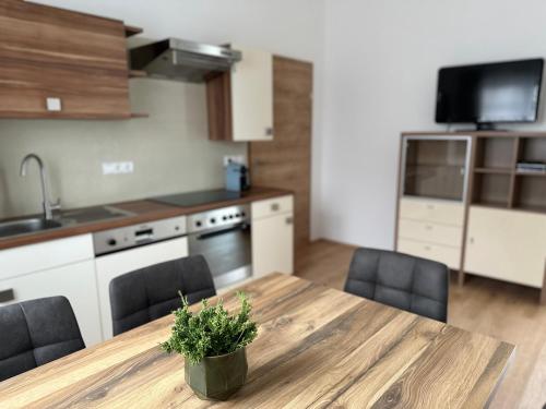 a kitchen with a wooden table with chairs and a kitchen with a sink at Ferienwohnung Schneeflock in Birkfeld