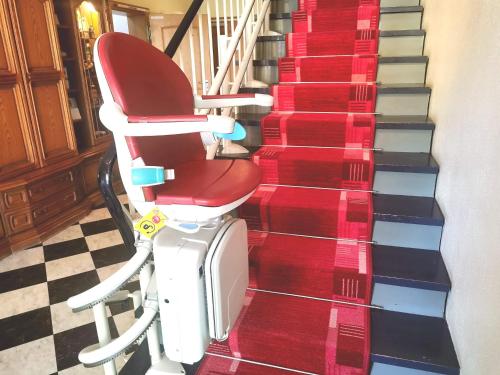 a red chair sitting next to a set of stairs at Landgasthof Leverenz "Traditionell & rustikal" in Neuenkirchen