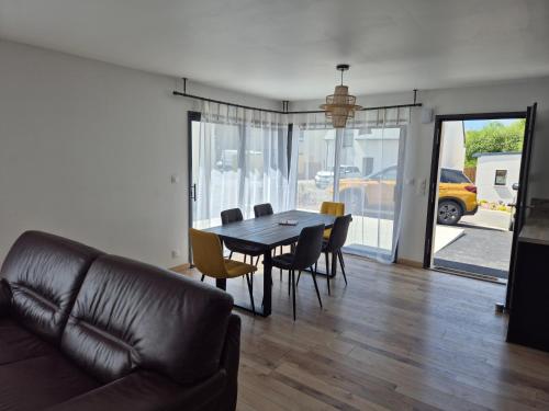 un salon avec une table, des chaises et un canapé dans l'établissement La belle évasion, à Perros-Guirec