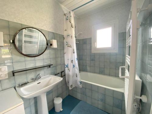 une salle de bain avec un lavabo, une baignoire et un miroir dans l'établissement Maison avec Jardin, WIFI, à 50m Plage - TREGASTEL - FR-1-368-31, à Trégastel
