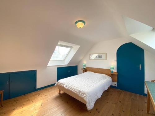 - une chambre avec un lit doté de placards bleus et une fenêtre dans l'établissement Maison avec Jardin, WIFI, à 50m Plage - TREGASTEL - FR-1-368-31, à Trégastel