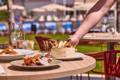 a person reaching for a dish on a table at Zafiro Alzinar Mar Adults Only - Refurbished 2025 in Can Picafort