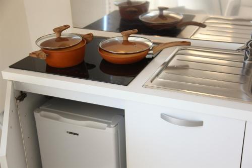 two pots on a stove top in a kitchen at Rest House The Village in Nardò