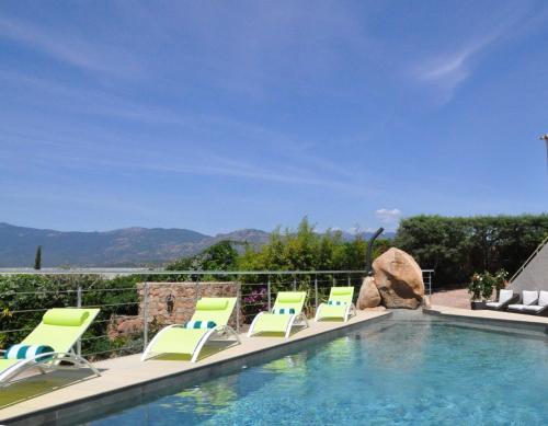a group of lawn chairs sitting next to a swimming pool at Private Hôtel - Adults Only in Porto-Vecchio