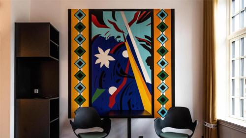 a large painting on the wall in a room with two chairs at ART Hotel Dalgas, BW Signature Collection in Brande