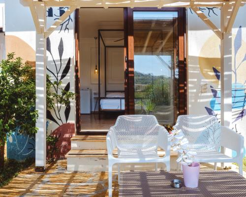 two white chairs sitting on a patio with a porch at Sea Garden Kaş Hotel in Kas