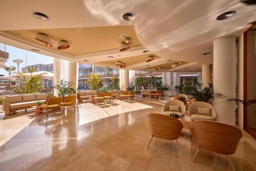 a lobby of a building with chairs and tables at Zafiro Alzinar Mar Adults Only - Refurbished 2025 in Can Picafort