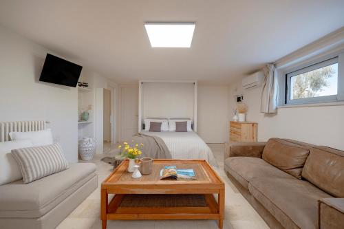 a living room with a couch and a bed at Trulli Casalina in Cisternino