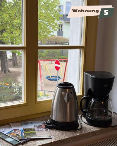 a coffee maker sitting on a counter next to a window at Ferienwohnung Zum Böhmischen Bürgergarten in Radebeul