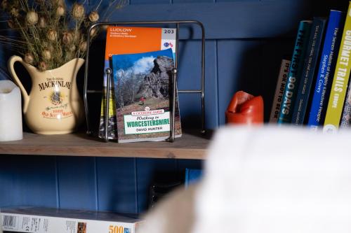 a book sitting on a shelf with books at Hanley House in Tenbury