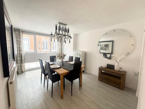 Un comedor con una mesa y sillas y un espejo. en Welcome Guests City Centre Apartment, en Chester