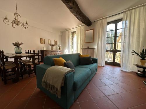 a living room with a green couch and a table at Palazzo Gamba Denti Apartment by Gottschalk in Bellano