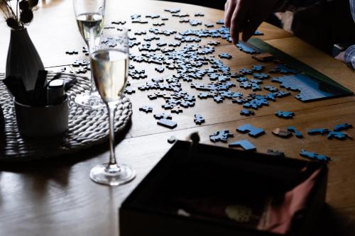 a glass of wine and a puzzle on a table at Hanley House in Tenbury