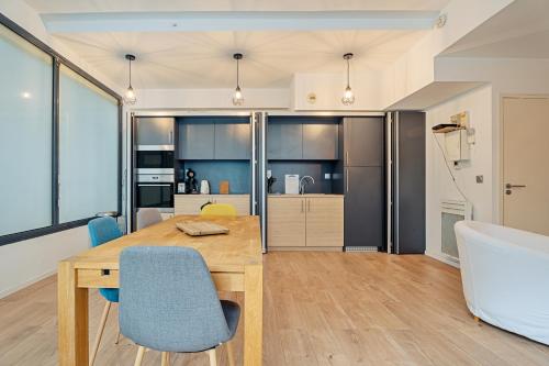une cuisine et une salle à manger avec une table et des chaises en bois dans l'établissement Studio Rennes - Proche Ste Anne, à Rennes