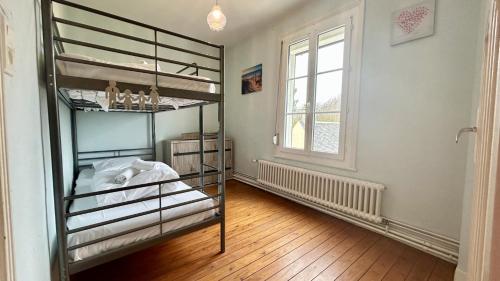une chambre avec deux lits superposés et une fenêtre dans l'établissement Maison de charme à Cayeux-sur-Mer – Idéale pour un séjour en famille ou entre amis !, à Cayeux-sur-Mer