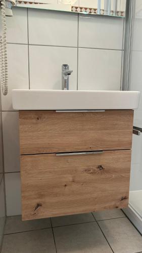 a bathroom with a white sink and a wooden drawer at Haus Jenny, Wohnung E3b, Sonne rundum in Boltenhagen