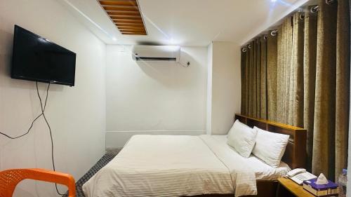 a small room with a bed and a television at Gulshan Palace 15 in Dhaka