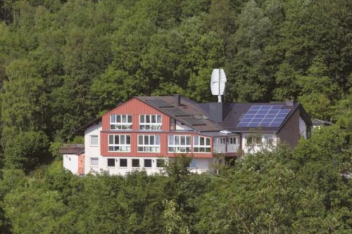 a house with solar panels on top of a hill at Belvita Ferienwohnung 1 mit Hallenbad & Sauna in Willingen