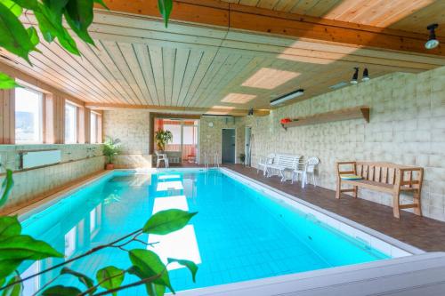 a large swimming pool with a wooden ceiling at Belvita Ferienwohnung 1 mit Hallenbad & Sauna in Willingen