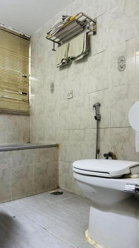 a bathroom with a toilet and a towel rack at Gulshan Palace 15 in Dhaka