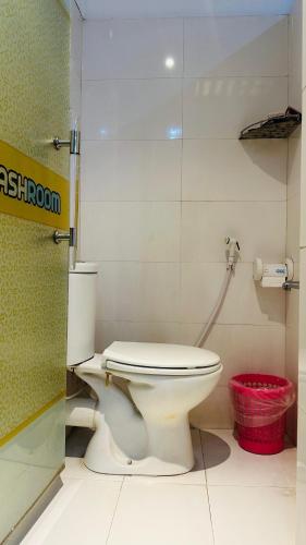 a bathroom with a toilet and a red basket at Gulshan Palace 15 in Dhaka