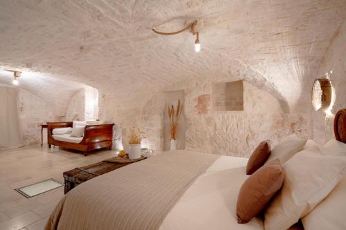 a bedroom with a large bed in a stone wall at Trulli Casalina in Cisternino
