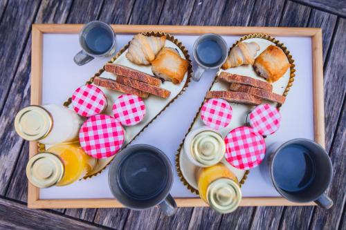 een bord met eten, brood en drinken op tafel bij Entre Couette & Bulles in Rivolet