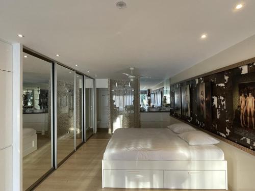 une chambre avec un grand lit blanc et une salle de bain dans l'établissement STUDIO MAXXX - Héliopolis E85 Luxe 4 personnes, au Cap d'Agde