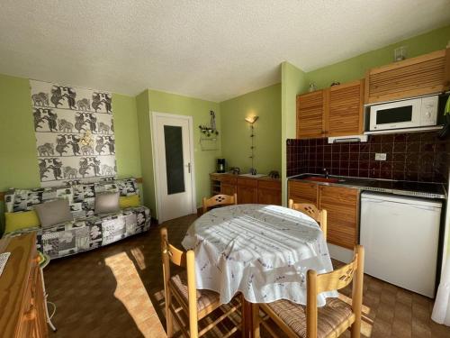 une cuisine avec une table et des chaises dans une pièce dans l'établissement Studio Héliopolis K114 - 4 personnes, au Cap d'Agde