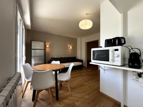 - un salon avec une table et un four micro-ondes dans l'établissement Bienvenue à l'Oustalet Appt 5, à Cazaubon
