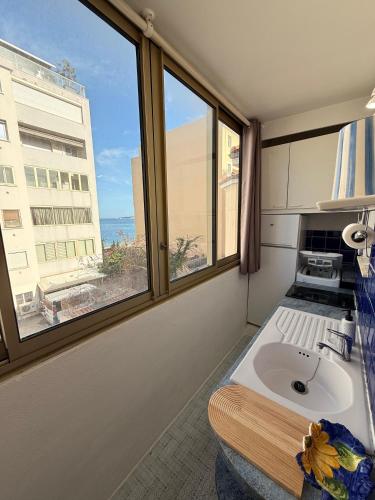 une salle de bain avec un lavabo et une fenêtre dans l'établissement Palm Beach Escape, à Cannes