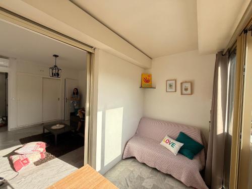 une petite pièce avec un lit et une fenêtre dans l'établissement Palm Beach Escape, à Cannes