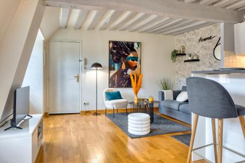 un salon avec un canapé et une télévision dans l'établissement Bienvenue au Solenne votre pied-à-terre de charme au cœur de Rouen, à Rouen