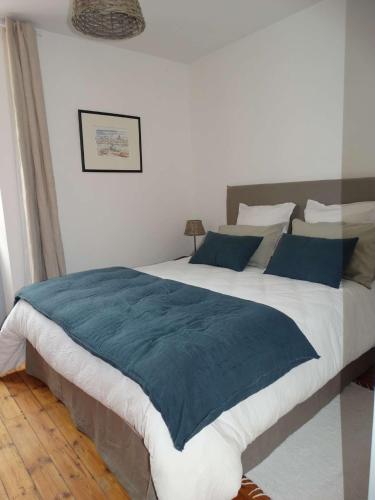 une chambre avec un grand lit avec des oreillers bleus dans l'établissement Oasis, à Saint-Gilles-Croix-de-Vie
