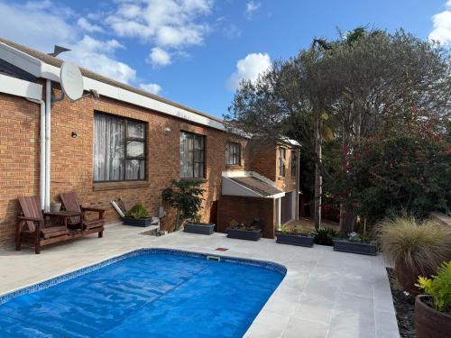 a backyard with a swimming pool and a house at Little Greece in Cape Town