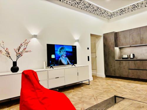 sala de estar con TV y sofá rojo en Villa Maria # 1, en Bad Oeynhausen