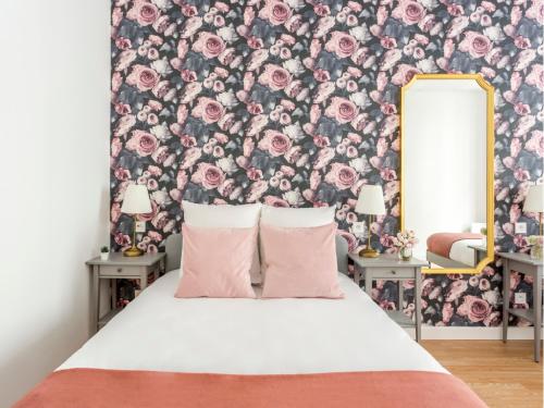 une chambre avec un papier peint fleuri et un lit avec des oreillers roses dans l'établissement Merveil - Family Suite - Marais - Martin III, à Paris