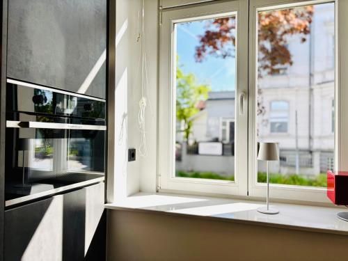 Una cocina con dos ventanas y una lámpara sobre una encimera. en Villa Maria # 1, en Bad Oeynhausen