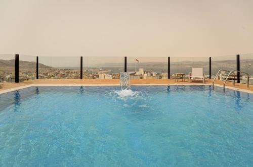 a large swimming pool with a view of a city at Coral Beach Hotel & Spa in Aqaba