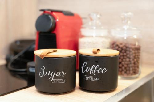 two containers of coffee sitting on a shelf with beans at MONOPATI Apartments in Mouzákion
