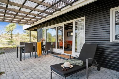 un patio avec une table et des chaises dessus dans l'établissement Cozy Nature Getaway Just Minutes From Ebeltoft And Top Attractions, à Ebeltoft