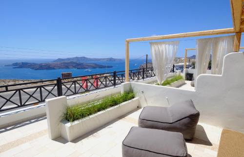 a balcony with chairs and a view of the ocean at IfestAu.4 Suites in Fira